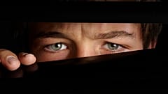 A man peeps from the blinds. 