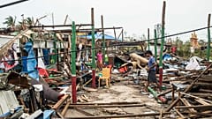 Des habitants nettoient les débris de leurs maisons détruites dans l'État de Rakhine au Myanmar, le 15 mai 2023