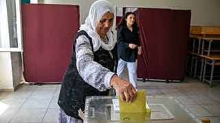Eine türkische Frau wirft ihren Wahlzettel in eine Urne ein