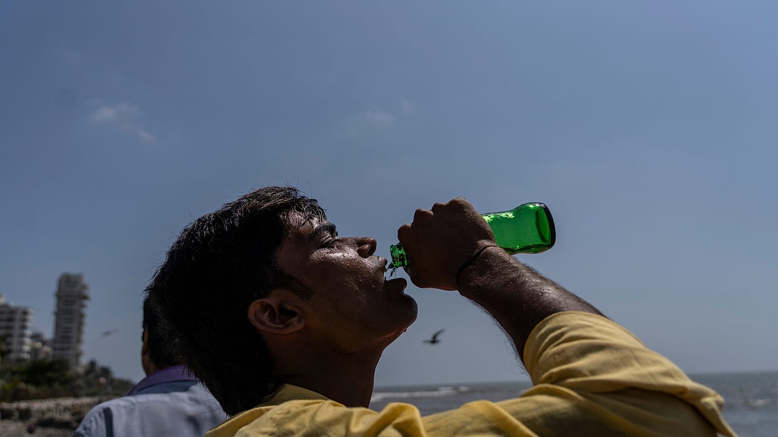 Un niño bebe refresco en un paseo marítimo de la costa del Mar Arábigo en Bombay, India.