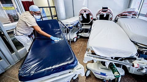A medical worker cleans gurneys in the emergency department intake area at NYC Health + Hospitals Metropolitan in New York, May 27, 2020. 