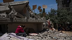 طفلة تجلس على أنقاض منزلها في غزة