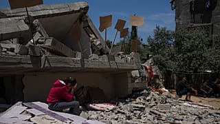 طفلة تجلس على أنقاض منزلها في غزة