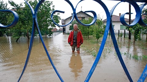 A Bosnian man stands in flooded water in front of his house in the village of Janja, near northern Bosnian town of Bijeljina, 130kms north east of Sarajevo.