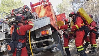 FILE - firefighters work to extinguish a forest fire in Fuente la Reina, eastern Spain, March 29, 2023.