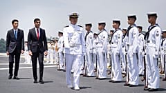 British Prime Minister Rishi Sunak and Japan's Vice Defense Minister Toshiro Ino inspect a guard of honour on board the Japanese aircraft carrier.