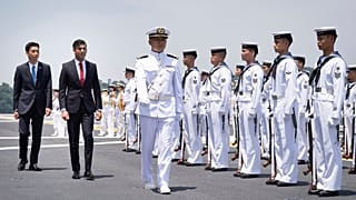 British Prime Minister Rishi Sunak and Japan's Vice Defense Minister Toshiro Ino inspect a guard of honour on board the Japanese aircraft carrier.