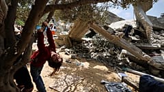 طفلة من عائلة نبهان الفلسطينية تلعب بالقرب من أنقاض منزلها في بيت لاهيا شمال قطاع غزة. 2023/05/15