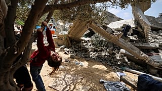 طفلة من عائلة نبهان الفلسطينية تلعب بالقرب من أنقاض منزلها في بيت لاهيا شمال قطاع غزة. 2023/05/15
