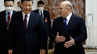 Russian Prime Minister Mikhail Mishustin, right, gestures as he speaks to Chinese President Xi Jinping during their meeting in Moscow, Russia, Tuesday, March 21, 2023.