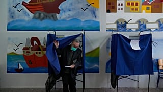 A man leaves the voting booth as he's votes at a polling station in Athens, Greece, Sunday, May 21, 2023.