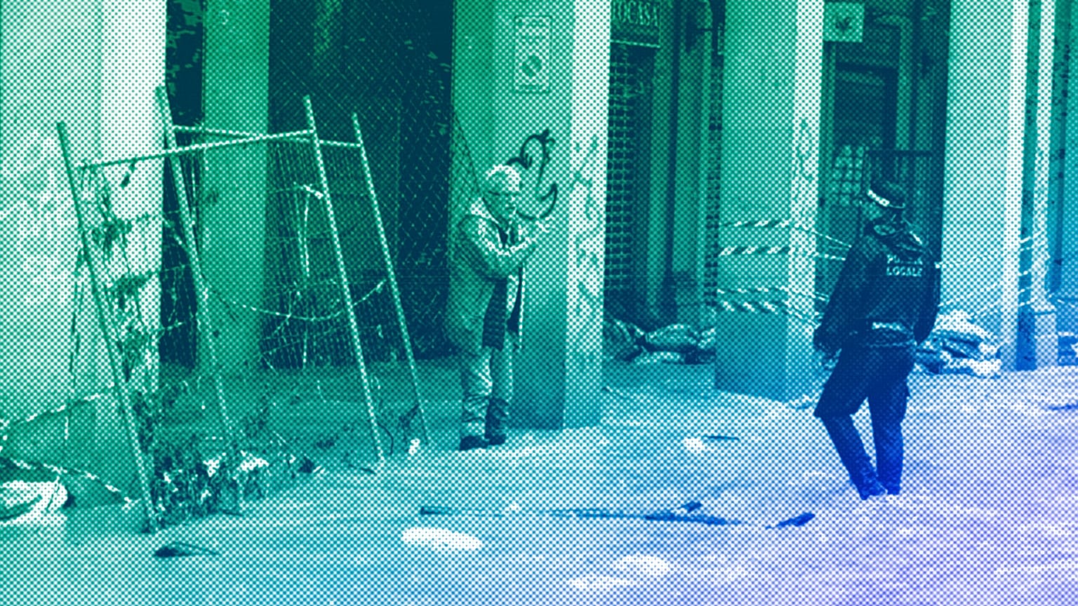 A man talks with a city police officer on a flooded street in Bologna, 17 May 2023