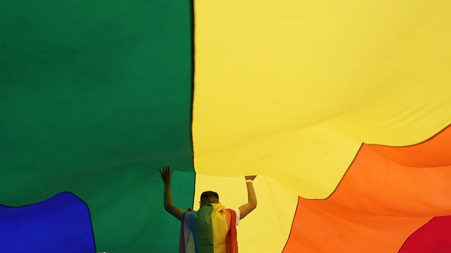 A participant holds up a large rainbow flag during the annual LGBT pride march in Belgrade, Serbia, Sept. 18, 2021. 