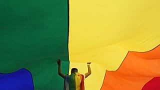 A participant holds up a large rainbow flag during the annual LGBT pride march in Belgrade, Serbia, Sept. 18, 2021.
