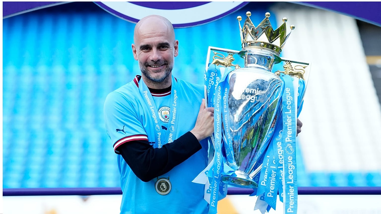 مدرب مانشستر سيتي بيب جوارديولا يقف مع الكأس أثناء احتفاله بلقب الدوري الإنجليزي الممتاز. مانشستر انجلترا، الأحد 21 مايو 2023.
