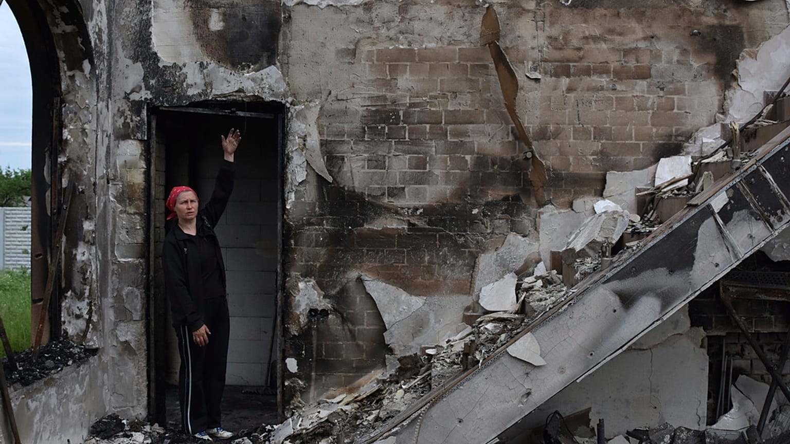 Eine Frau vor einem zerstörten Gebetshaus in der ukrainischen Stadt Orihiv