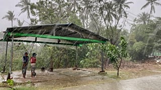 Two children stand under a roadside shelter to protect from rain before Cyclone Mocha hits in Sittwe, Rakhine State.