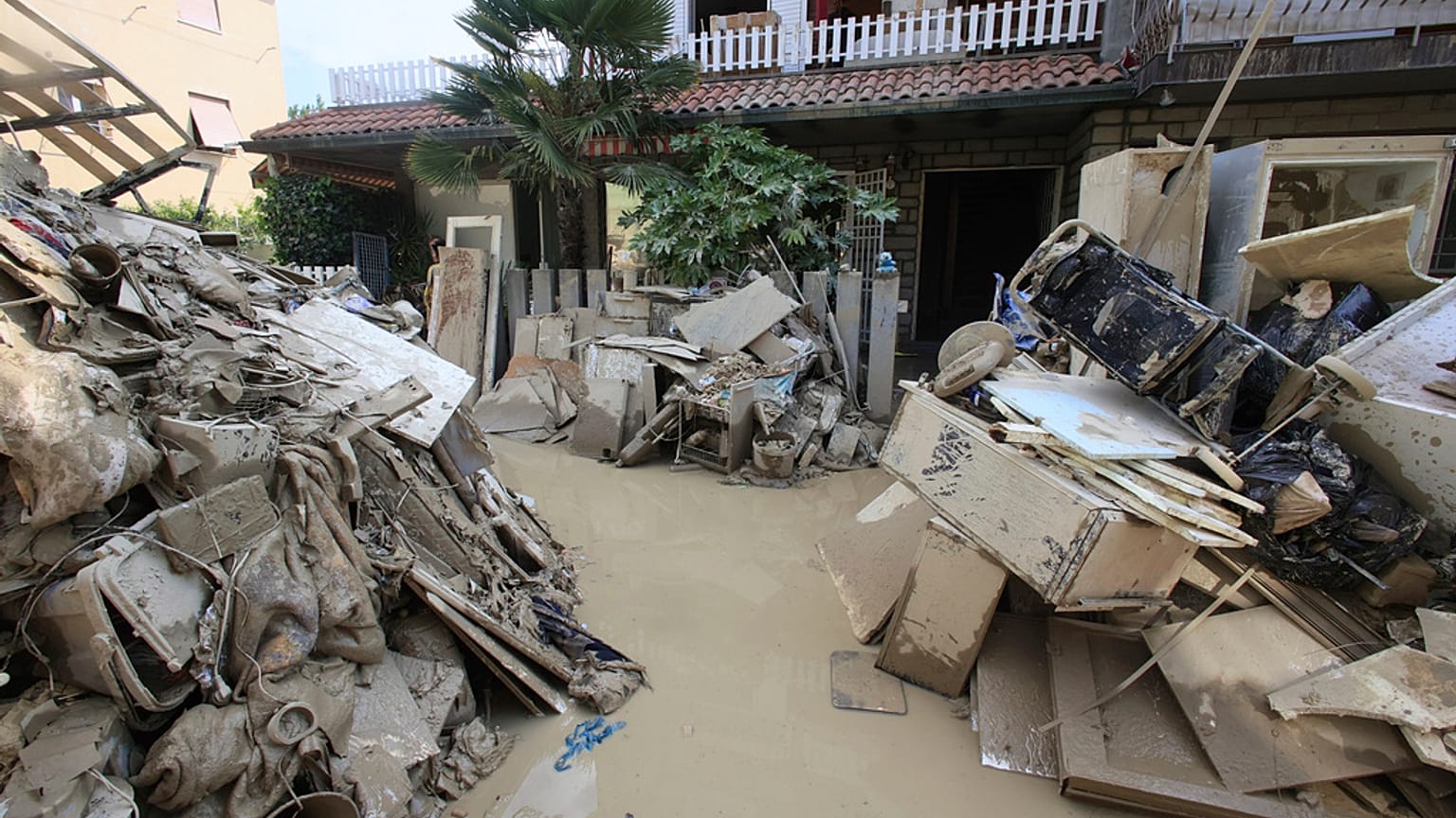 Household goods are piled outside a building after heavy flooding, in Faenza, Italy, Monday, May 22, 2023