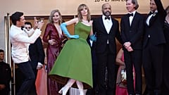 Umgeben von Schauspieler:innen posiert Wes Anderson auf den Treppen des Festspielhauses.