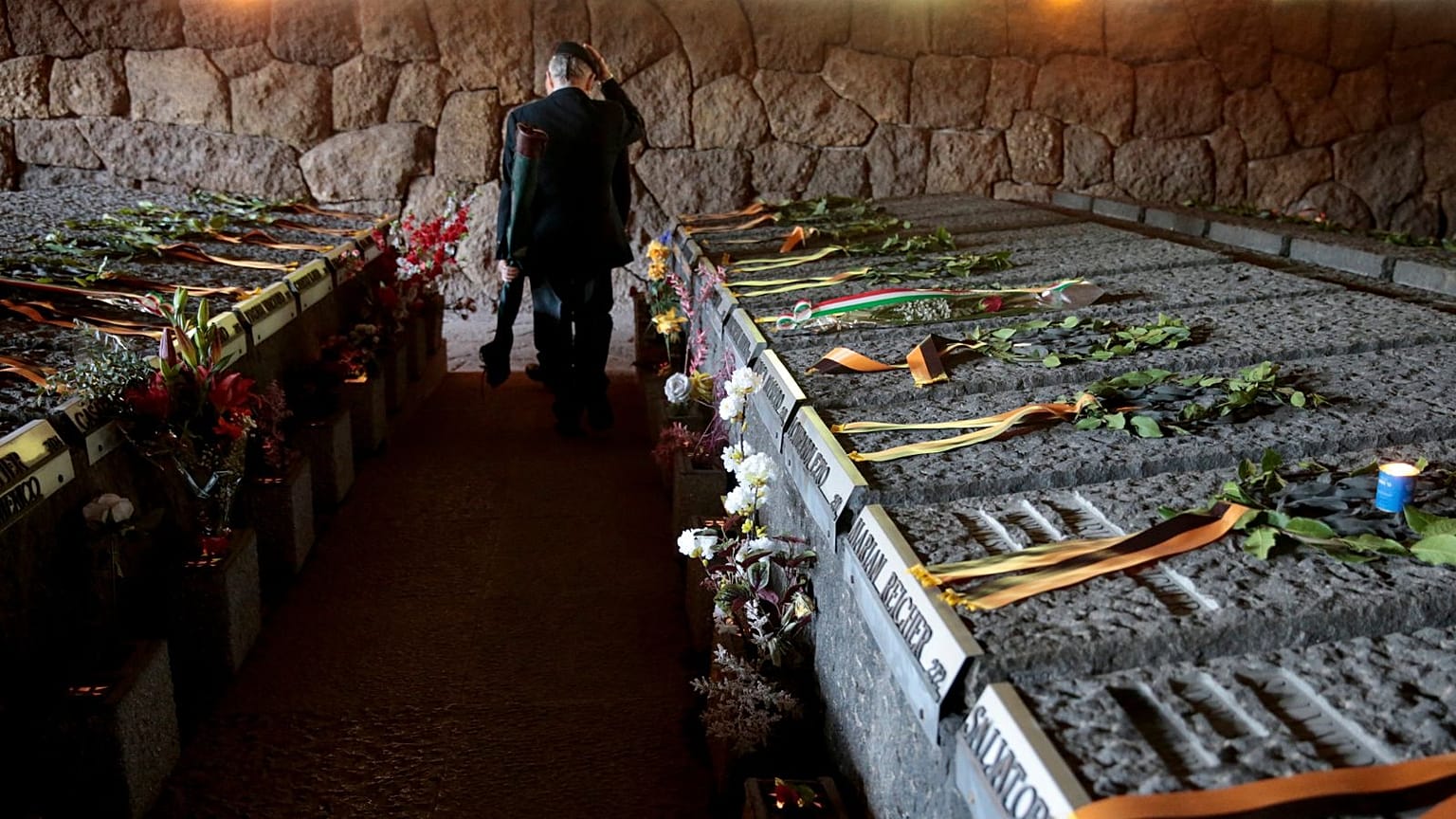 A man walks amid the graves of the 335 victims of one of the worst World War II-era massacres in German-occupied Italy at the Ardeatine Caves in Rome, on 24 March 2023. 
