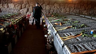 A man walks amid the graves of the 335 victims of one of the worst World War II-era massacres in German-occupied Italy at the Ardeatine Caves in Rome, on 24 March 2023.