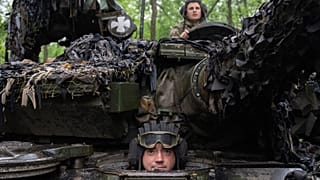 Soldados ucranianos en un tanque miran mientras recorren la carretera hacia sus posiciones cerca de Bakhmut, región de Donetsk, Ucrania, martes 23 de mayo de 2023