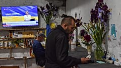 Мужчина заряжает мобильный телефон в "пункте несокрушимости". Гуляйполе, Запорожская область, Украина. 25 мая 2023.