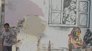Una obra de Alaa Rubil en la pared de una casa destruida en Adén