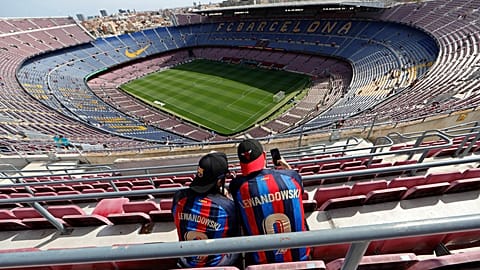Two Barcelona fans wait for the start of a Spanish La Liga soccer match between Barcelona and Mallorca at the Camp Nou stadium in Barcelona