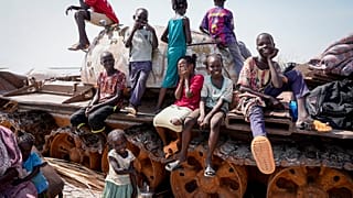 Children sit and play on the remains of a tank, at the river port in Renk, South Sudan Wednesday, May 17, 2023.
