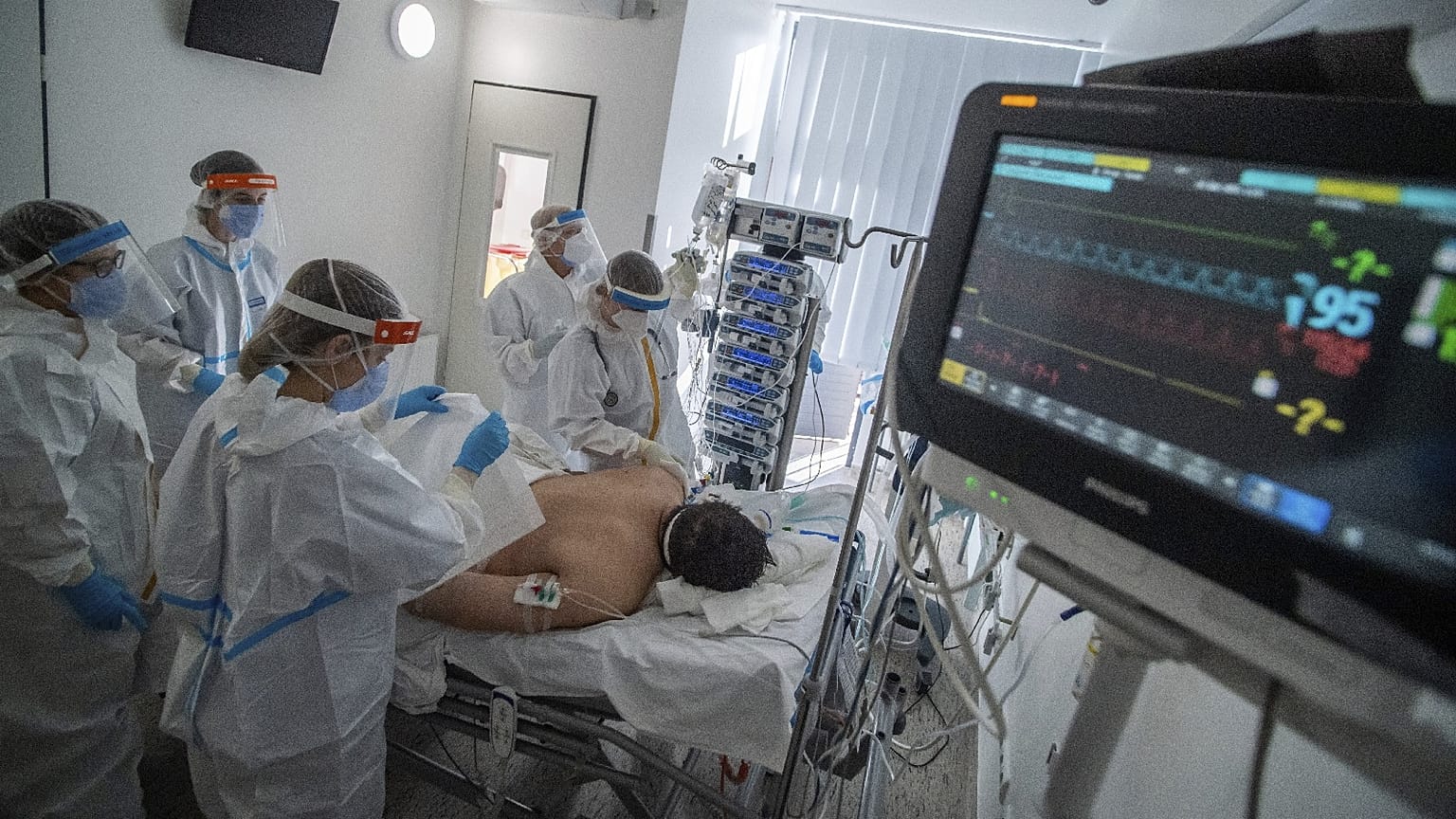 Doctors and nurses wearing protective gears attend a patient on ventilator at the ICU of Szent Laszlo Hospital, in Budapest, treating COVID-19 patients, Dec. 13, 2021.