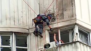 Investigators inspect the building after a Ukrainian drone damaged an apartment building in Moscow, Russia, Tuesday, May 30, 2023.