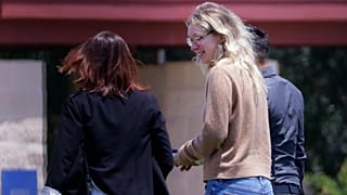 Disgraced Theranos CEO Elizabeth Holmes bieng escorted by prison officials into a federal women’s prison camp. 