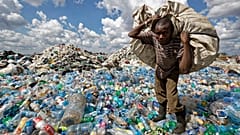 Kenya'nın başkenti Nairobi'de bir gecekondu mahallesinde geri dönüşüm için satmak üzere plastik atık toplayan bir vatandaş