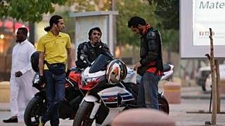  شبان سعوديون يقفون بجانب دراجاتهم النارية في أحد شوارع الرياض
