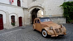 French cabinetmaker Michel Robillard driving his wooden 2CV Citroen car in the streets of Loches.