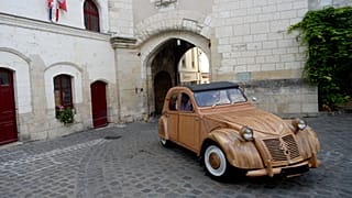 French cabinetmaker Michel Robillard driving his wooden 2CV Citroen car in the streets of Loches.