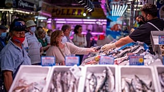 A customer pays for fish at the Maravillas market in Madrid, on May 12, 2022.