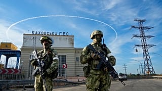 Russian troops guard an entrance of the Kakhovka Hydroelectric Station in Kherson region