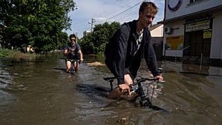 Menschen im vom zerstörten Staudamm überfluteten Gebiet in der Ukraine