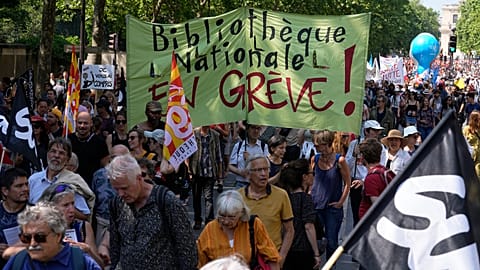 Demonstrators hold a placard reading 'National library on strike' as they attend a protest march in Paris