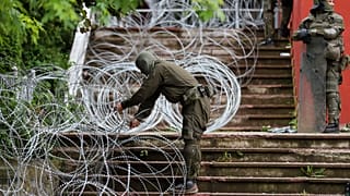 KFOR katonák szögesdrótot helyeznek el a városháza előtt az észak-koszovói Zvečanban 2023. május 31-én