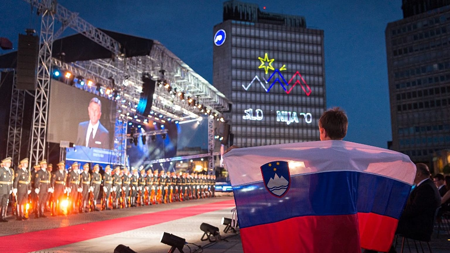 A boy holds a Slovenian flag during the ceremony to celebrate the 30th Anniversary of Slovenian independence in Ljubljana.