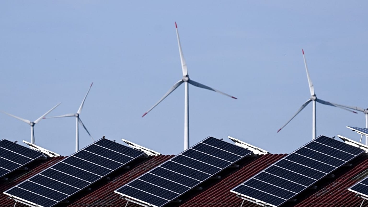 Solar panels of a building and wind turbines are pictured near Lichtenau, western Germany.