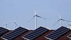 Solar panels of a building and wind turbines are pictured near Lichtenau, western Germany.