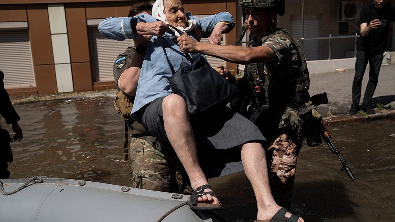 A woman is evacuated from a flooded neighborhood in Kherson, Ukraine, Wednesday, June 7, 2023 after the walls of the Kakhovka dam collapsed.