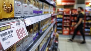 Bevásárló egy budapesti CBA-üzletben, az előtérben egy akciós árcédulával