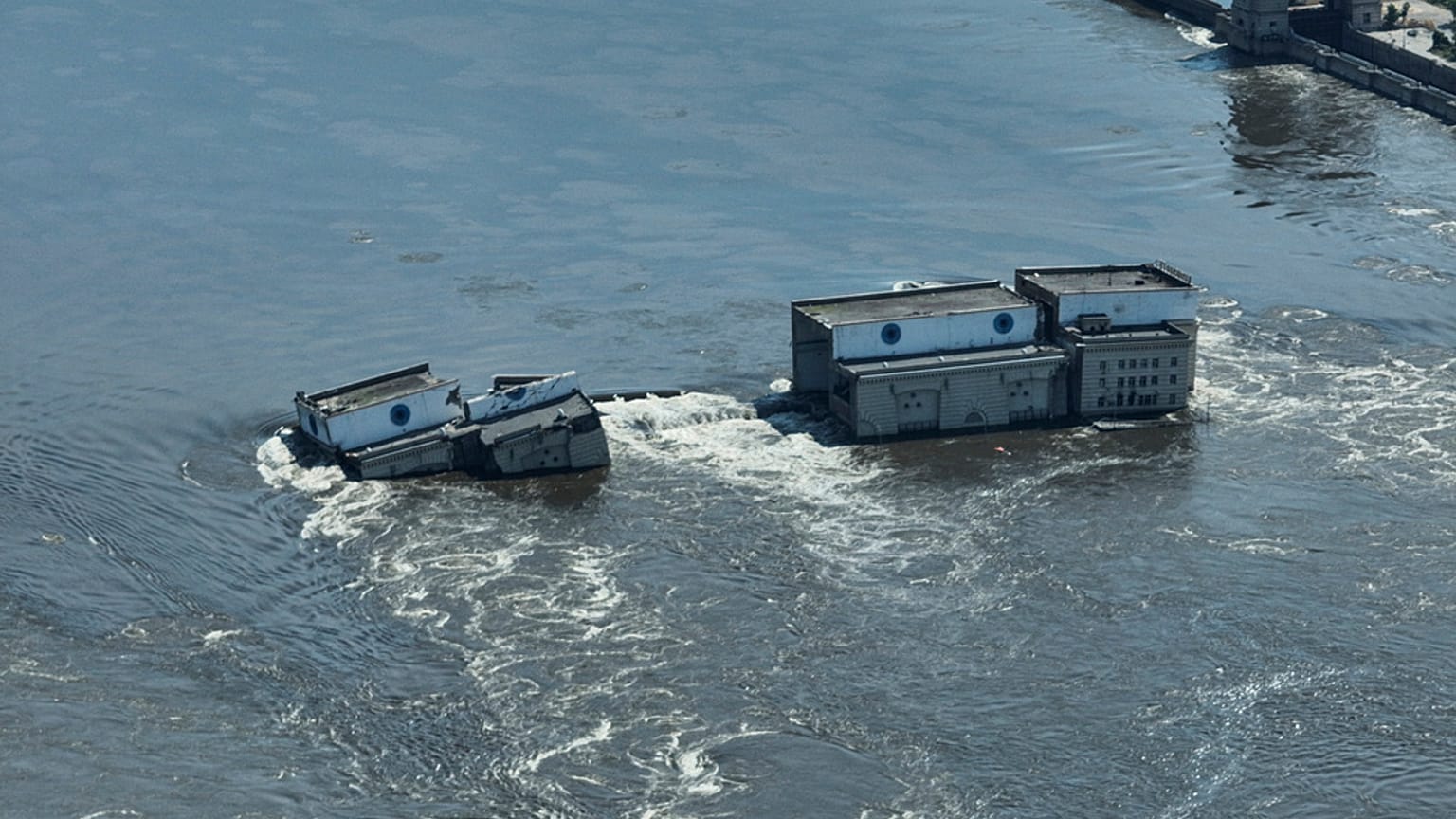 El agua fluye sobre la presa derrumbada de Nueva Kajovka, en la Ucrania ocupada por Rusia, el miércoles 7 de junio de 2023
