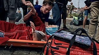 Rettungskräfte evakuieren eine ältere Bewohnerin aus einem überschwemmten Viertel in Cherson, Ukraine, 8. Juni 2023.