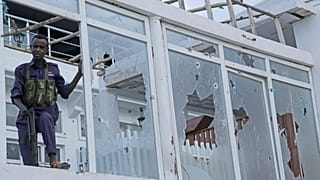 A Somali soldier stands guard with destroyed window of the Pearl Beach hotel in Mogadishu, Somalia, Saturday, June 10, 2023. 